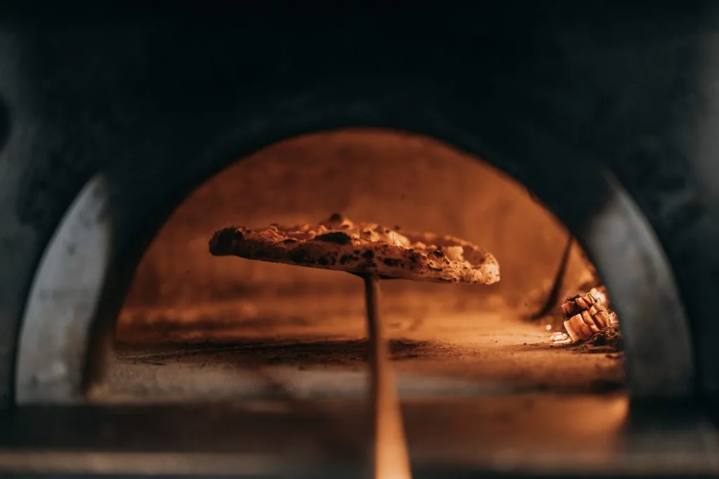 Pizza en cuisson dans le four à bois